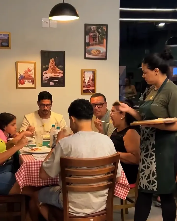 Família reunida à mesa sendo servida pela garçonete